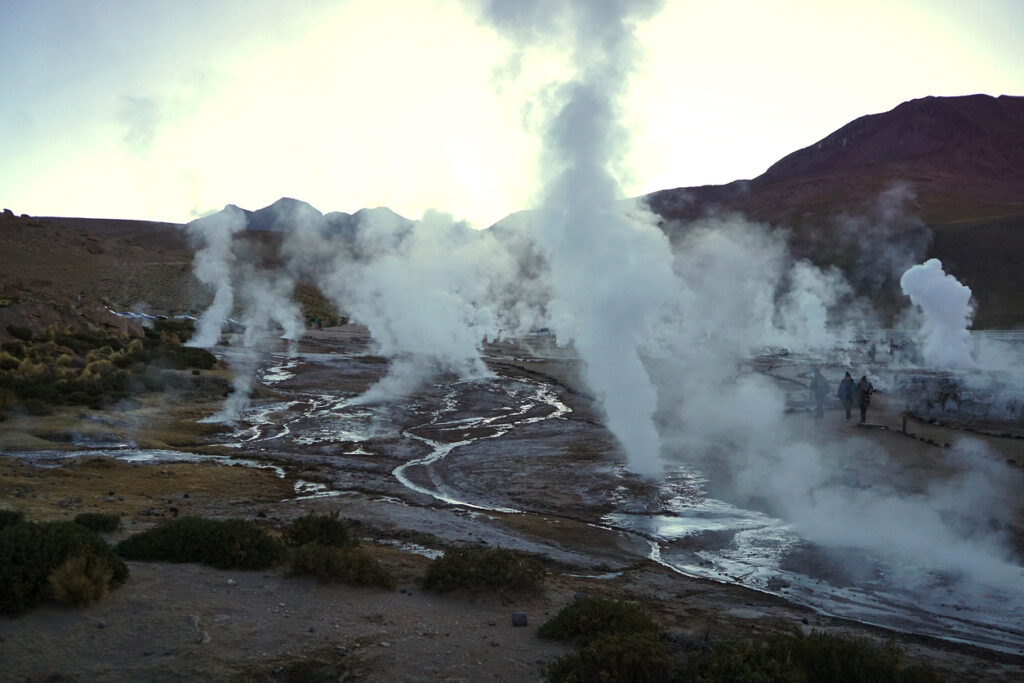 Geysire nahe San Pedro de Atacama, Chile, stoßen weißen Dampf über ein geothermal aktives Feld aus.