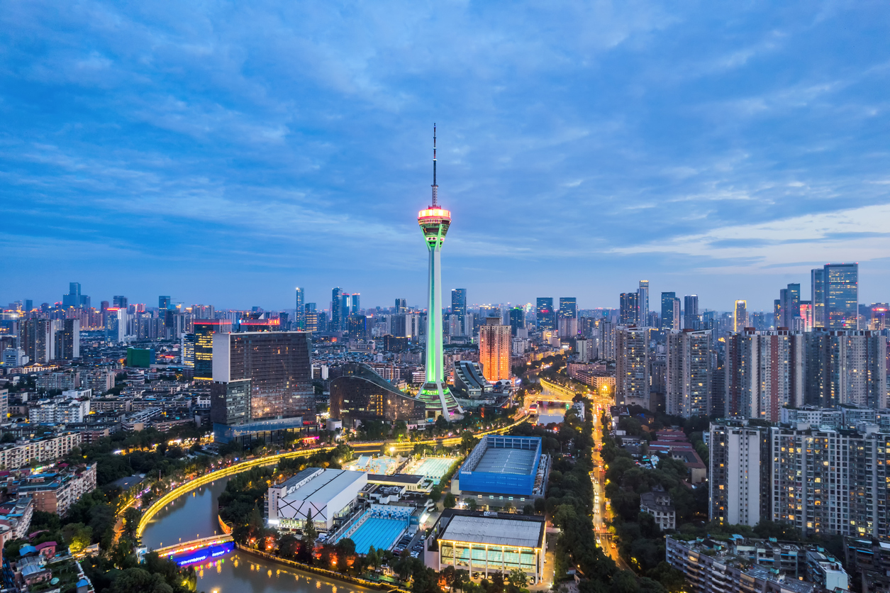 Panorama der nächtlich beleuchteten Skyline von Chengdu mit hohem Fernsehturm und Fluss.