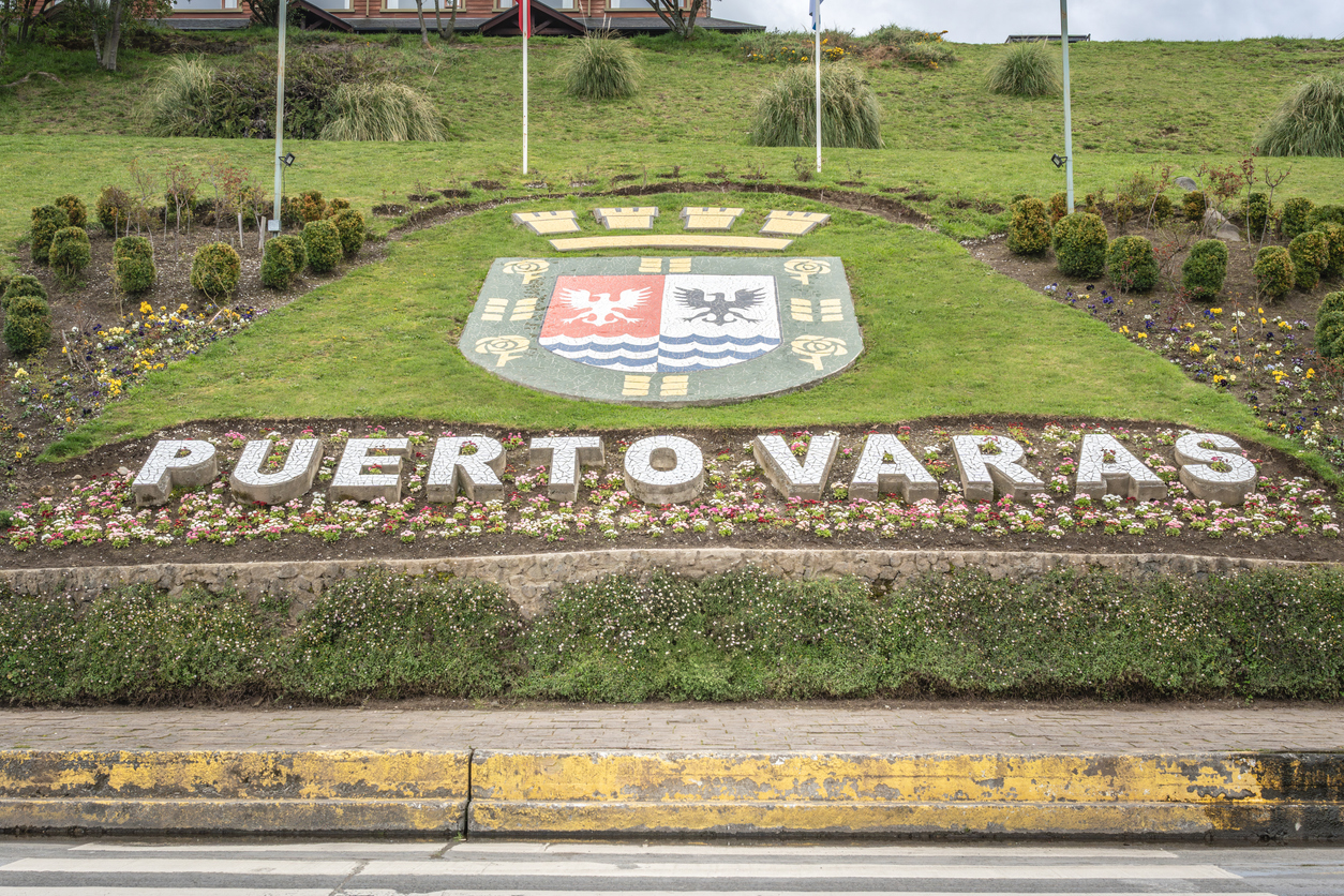 Ein bepflanztes Schild mit dem Schriftzug Puerto Varas steht an einer Böschung in Puerto Varas, Chile.