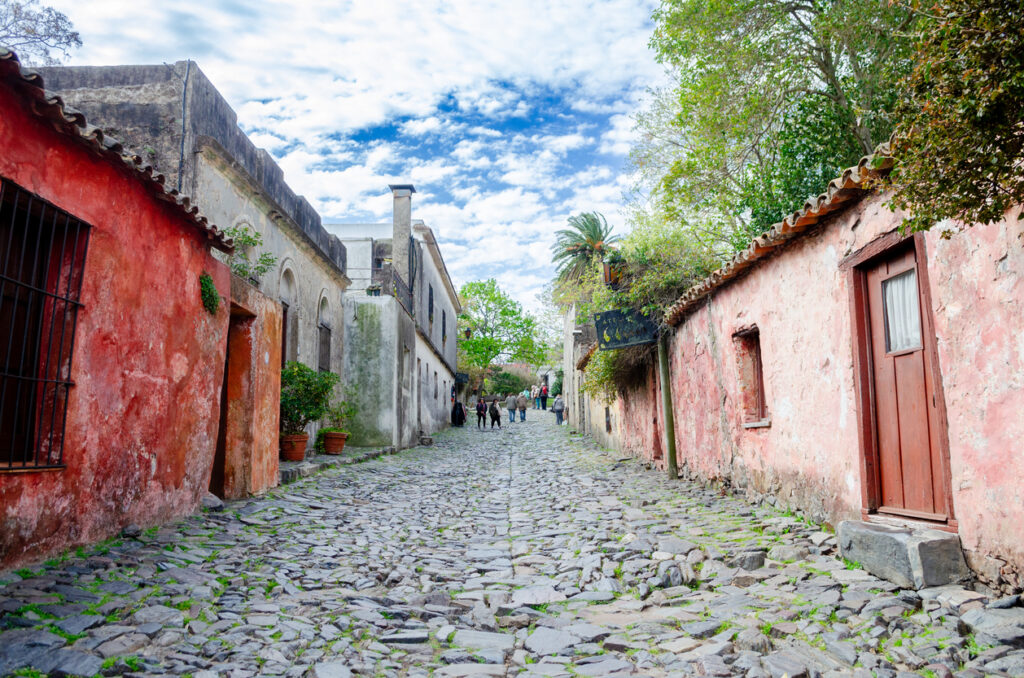 Bunte alte Häuser säumen eine steile Kopfsteinpflasterstraße in Colonia del Sacramento.