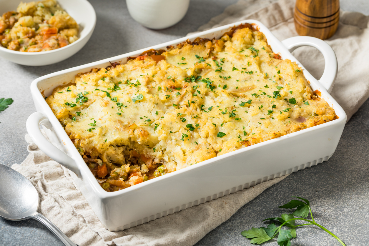 Auflaufform mit goldbraun überbackenem Shepherd’s Pie auf einem Küchentuch.