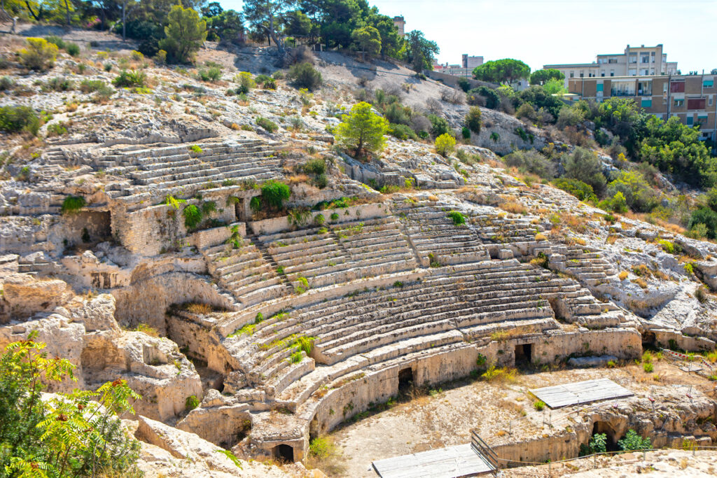 Steinernes römisches Amphitheater in Cagliari, das sich terrassenförmig in einen Hügel schmiegt.