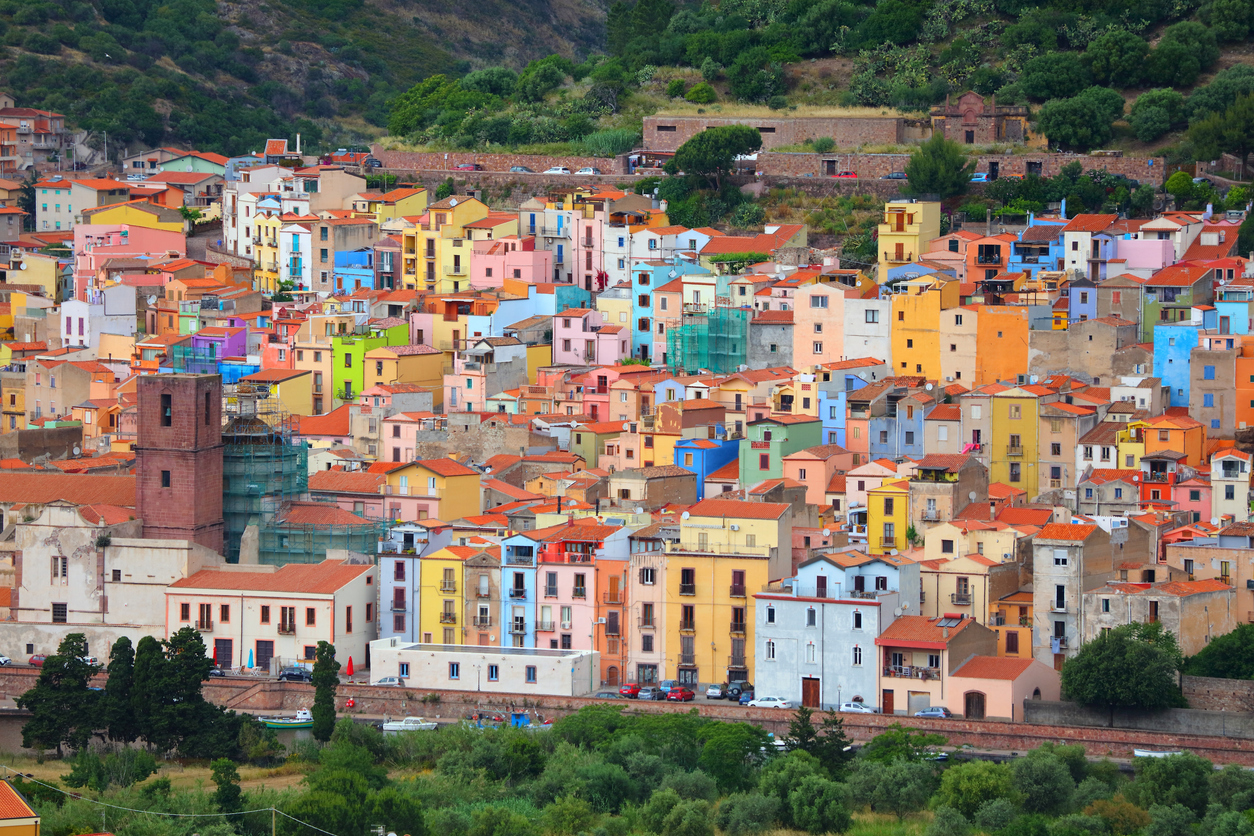Panorama von Bosa mit dicht aneinander gebauten, farbenfrohen Häusern am Hang unterhalb der Burg auf Sardinien.