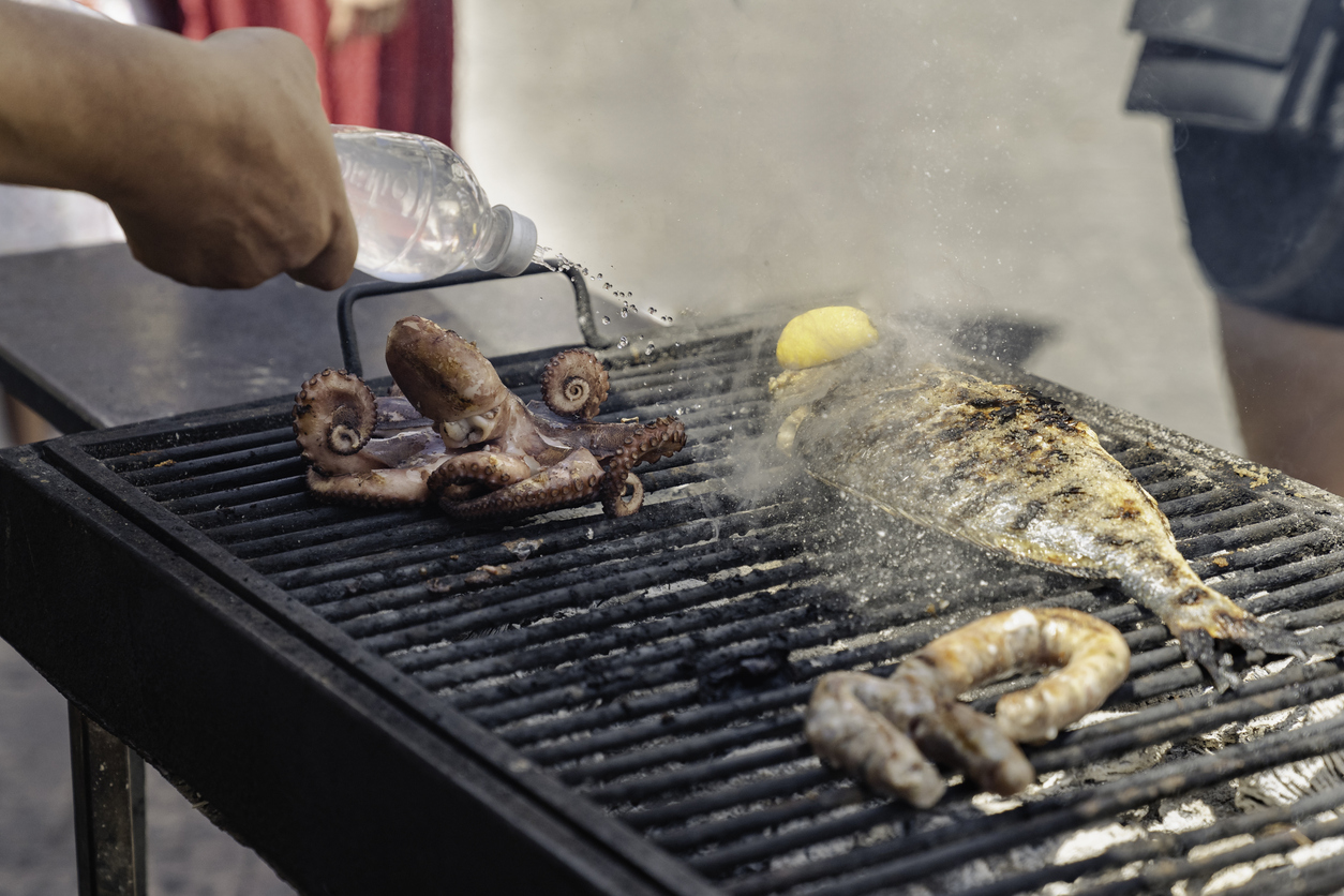 Gegrillter Fisch und Oktopus auf einem heißen Straßengrill in Palermo.