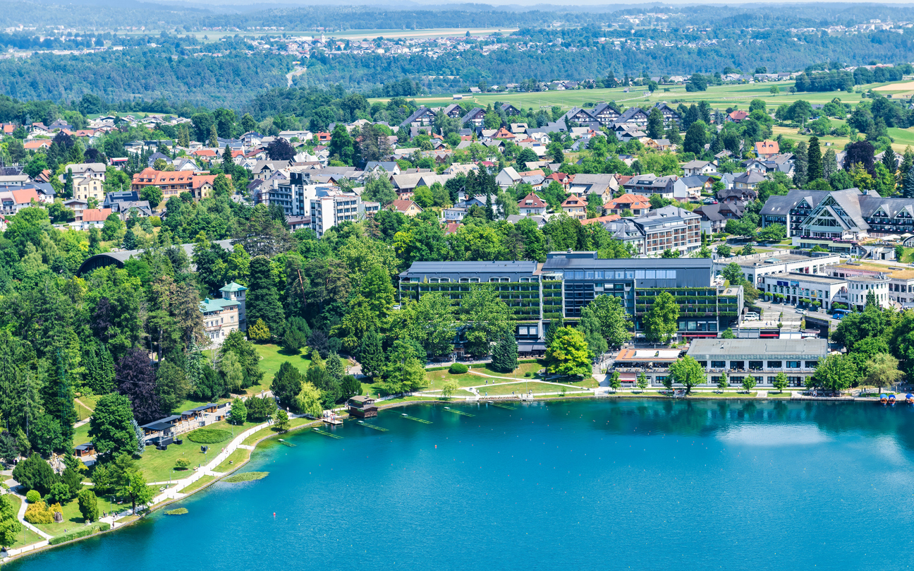 Luftaufnahme von Bled mit Hotels, Häusern und dem türkisfarbenen Bleder See in Slowenien.