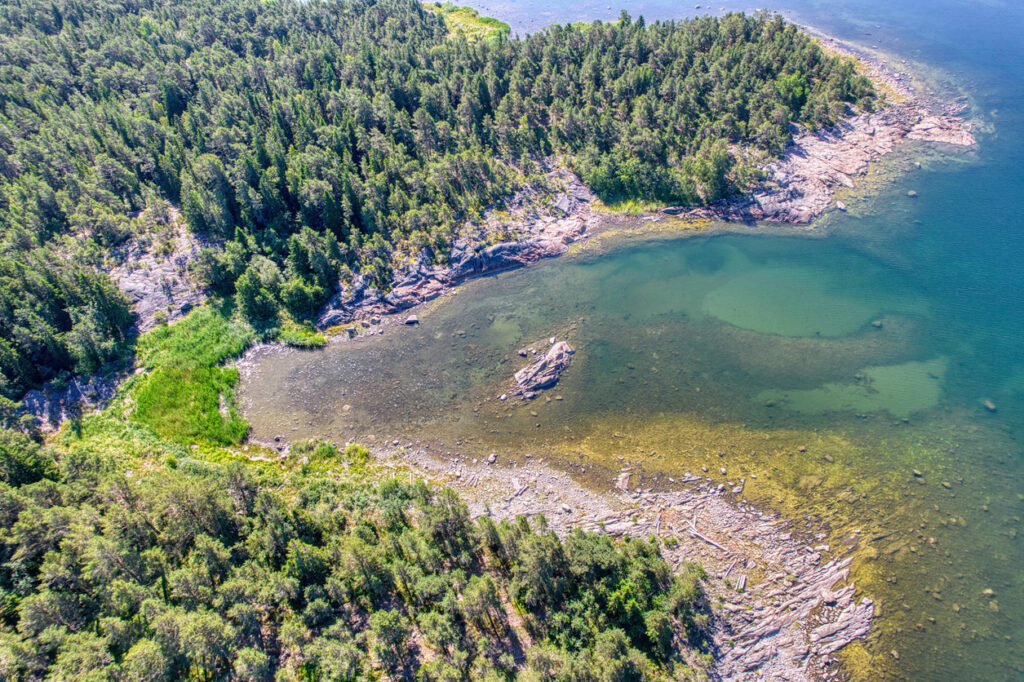 Luftaufnahme einer felsigen Küste mit Wald und klaren Buchten im Bottnischen Meerbusen.
