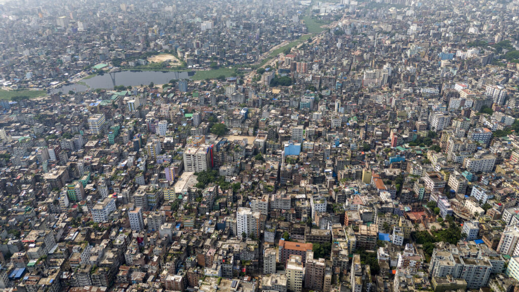 Weite Luftaufnahme von Dhaka mit einem Meer aus dicht stehenden Wohnhäusern.