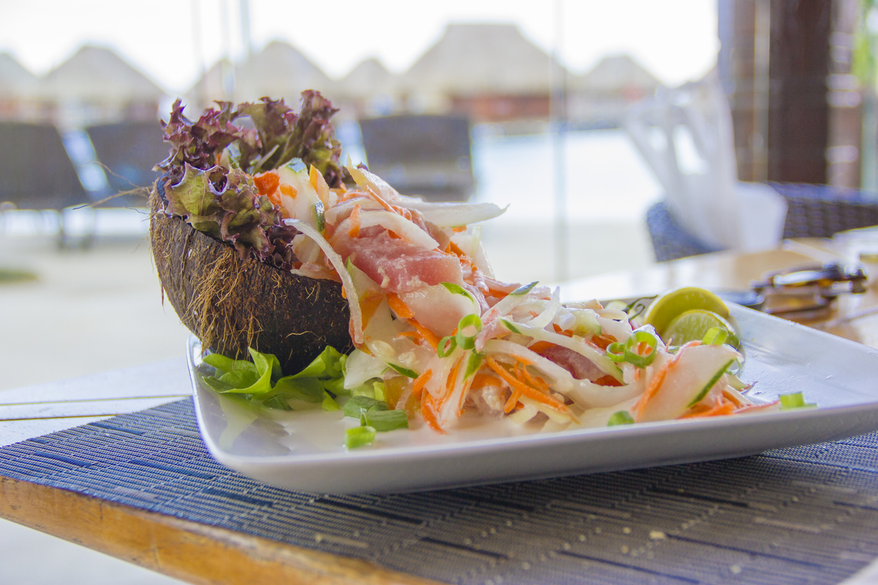Typisches Gericht aus rohem Fisch und Gemüse in einer Kokosnussschale wird in Französisch-Polynesien serviert.