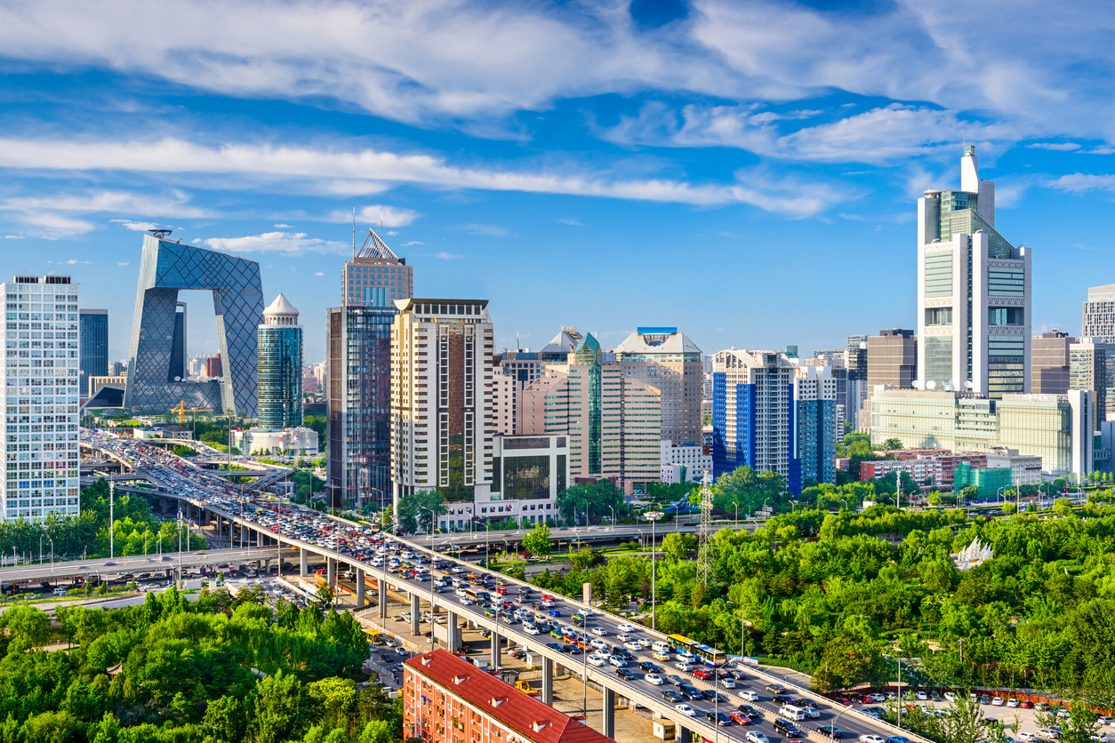 Blick auf die moderne Skyline von Peking mit Hochhäusern und Stadtautobahn an einem klaren Tag.