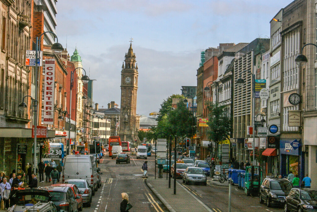 Belebte Straße in Belfast mit dem Albert Memorial Clock im Hintergrund.