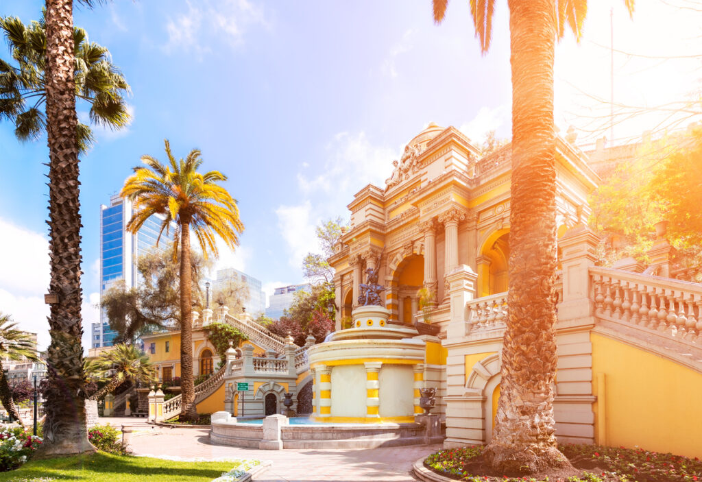 Ein historisches Gebäude mit Treppen und Brunnen steht zwischen Palmen in Santiago, Chile.