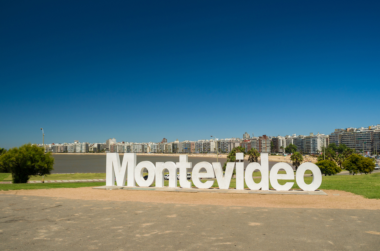 Weißer „Montevideo“-Schriftzug vor Skyline und Wasser in Montevideo, Uruguay.