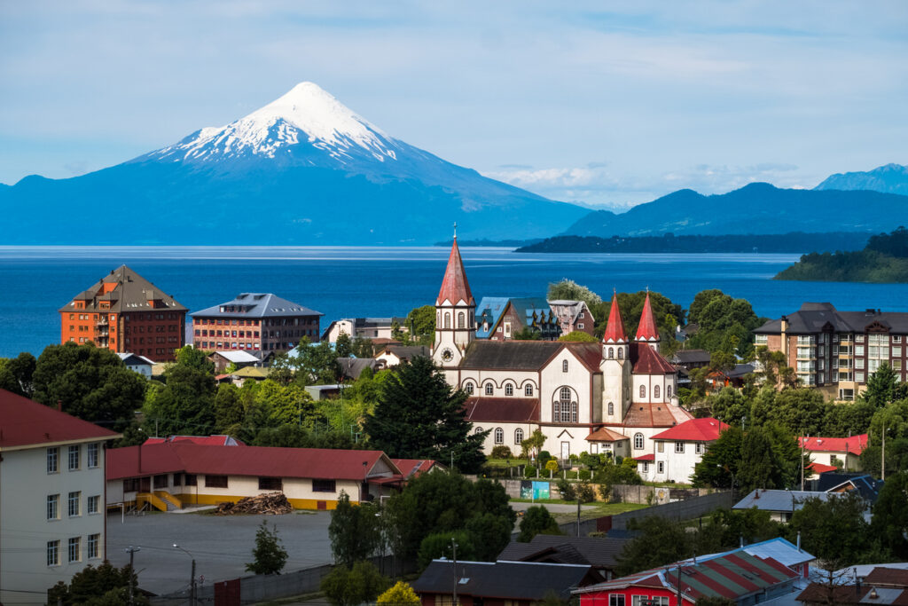 Puerto Varas, Chile, mit Kirche und Häusern am See und dem Vulkan Osorno im Hintergrund.
