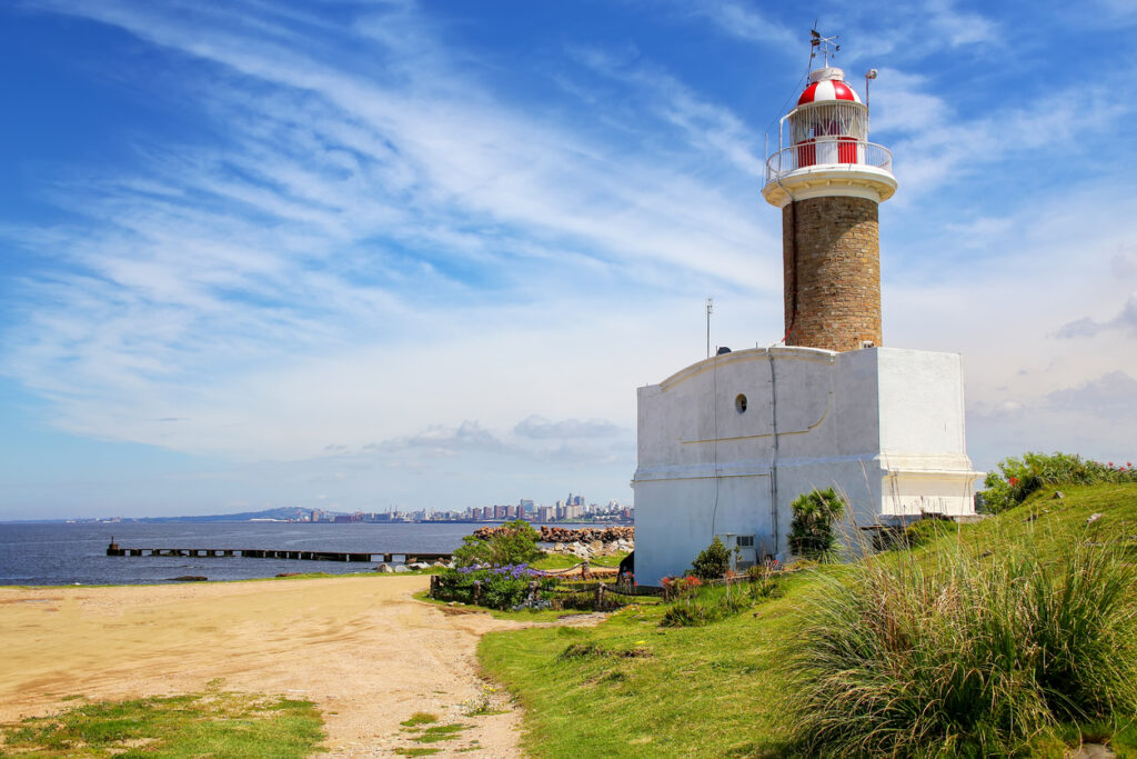Historischer Leuchtturm an der Küste mit Montevideo im Hintergrund, Uruguay.