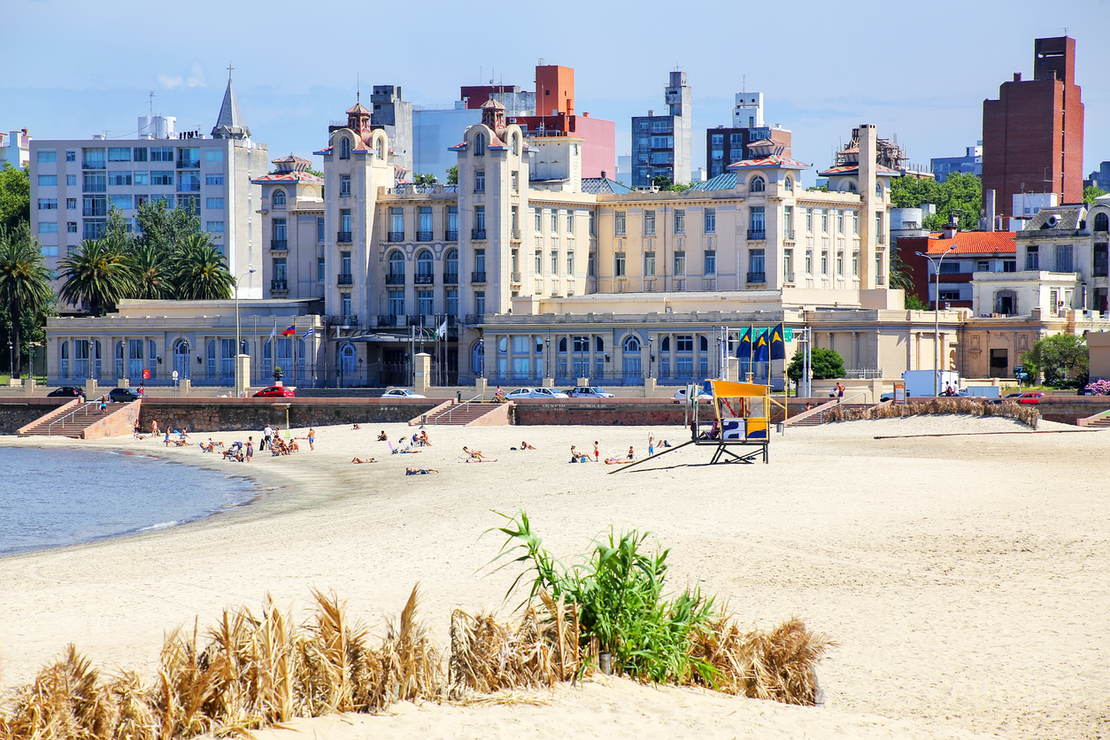 Sandstrand mit historischem Gebäude am Wasser in Montevideo, Uruguay.