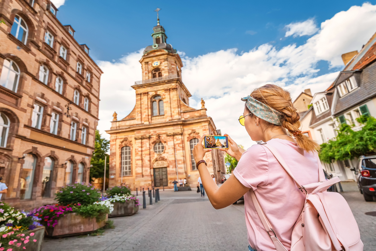 Besucherin fotografiert eine barocke Kirche in der Altstadt von Saarbrücken.