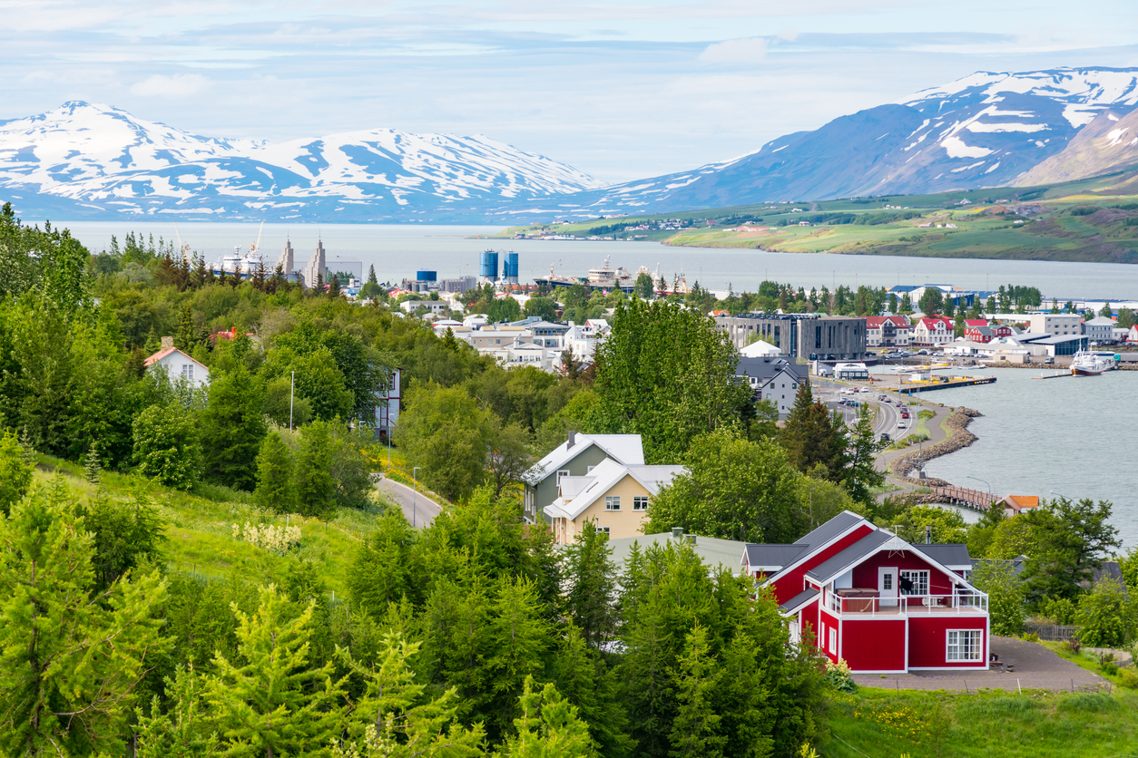 Panorama von Akureyri am Fjord mit schneebedeckten Bergen im Hintergrund.