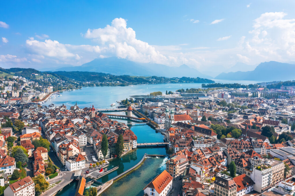 Panoramablick über Luzerns Altstadt mit Reuss, Vierwaldstättersee und Bergen im Hintergrund.