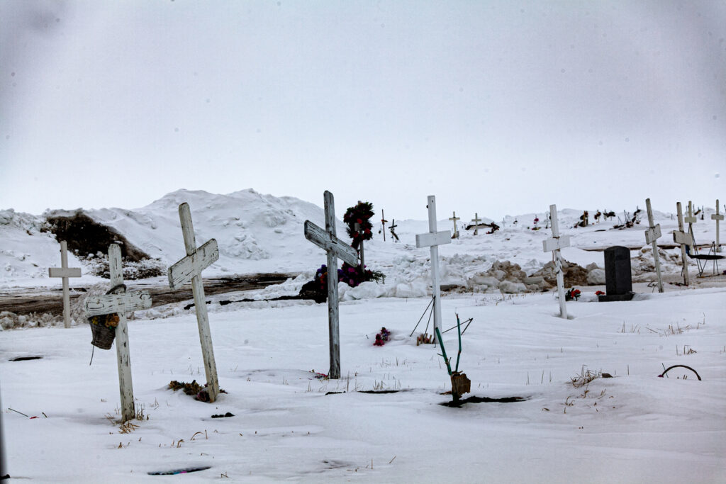 Weiße Holzkreuze stehen auf einem schneebedeckten Friedhof in Utqiaġvik (Barrow).