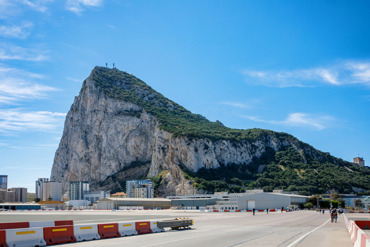 Der Felsen von Gibraltar ragt hinter der weiten Fläche des Flughafens in den Himmel.