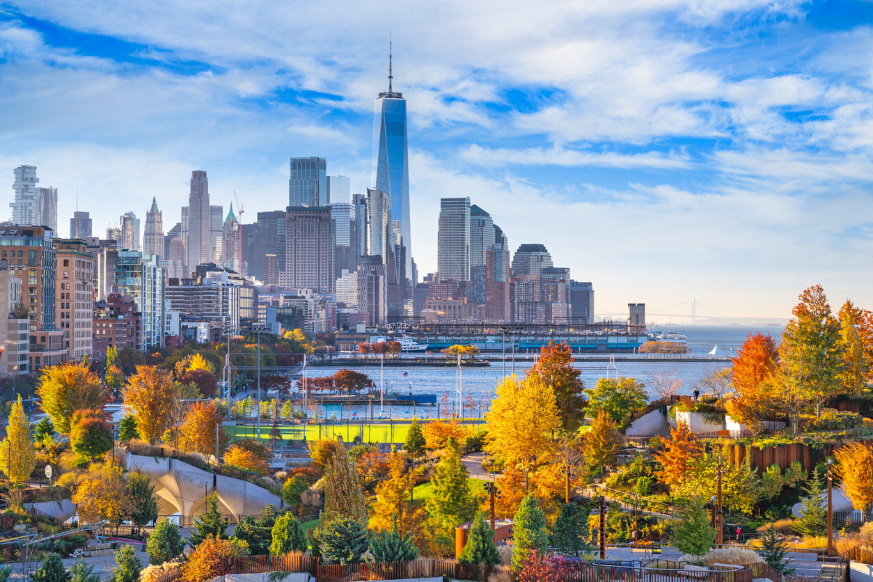 Bunte Herbstbäume rahmen die Skyline von New York mit One World Trade Center ein.