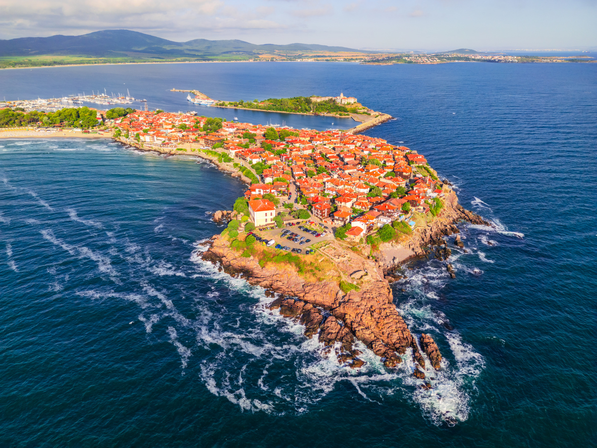 Eine Luftaufnahme zeigt eine dicht bebaute Halbinsel mit roten Dächern umgeben vom Meer in Bulgarien.