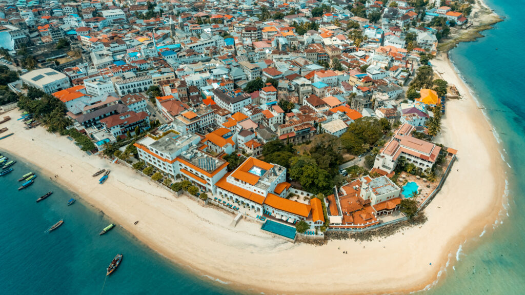 Die Altstadt und Küste von Stone Town liegen zwischen roten Dächern und blauem Wasser auf Sansibar.