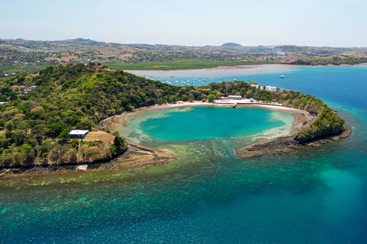 Eine runde Bucht mit Riffen und Booten liegt vor der Küste von Madagaskar.