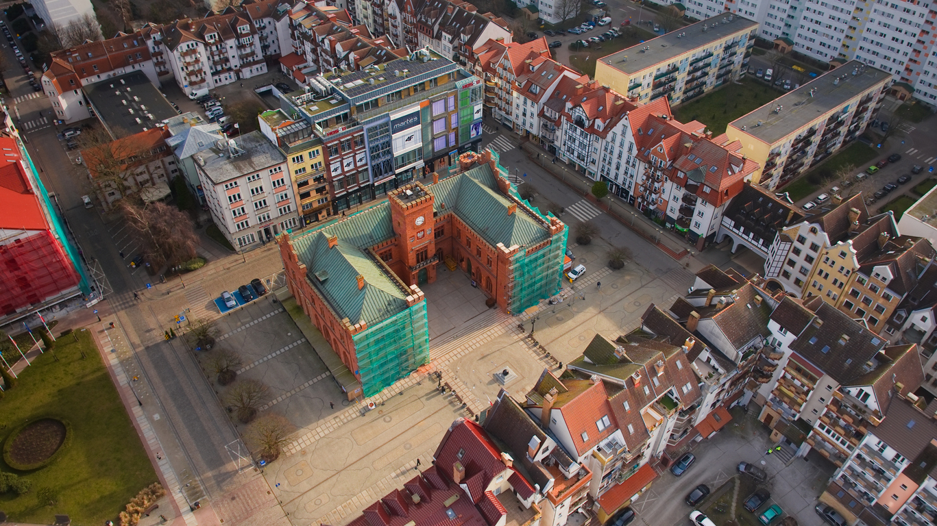 Aus der Luft sieht man das Rathaus und die umliegenden Straßen von Kolberg zwischen Altstadt und Wohnvierteln.