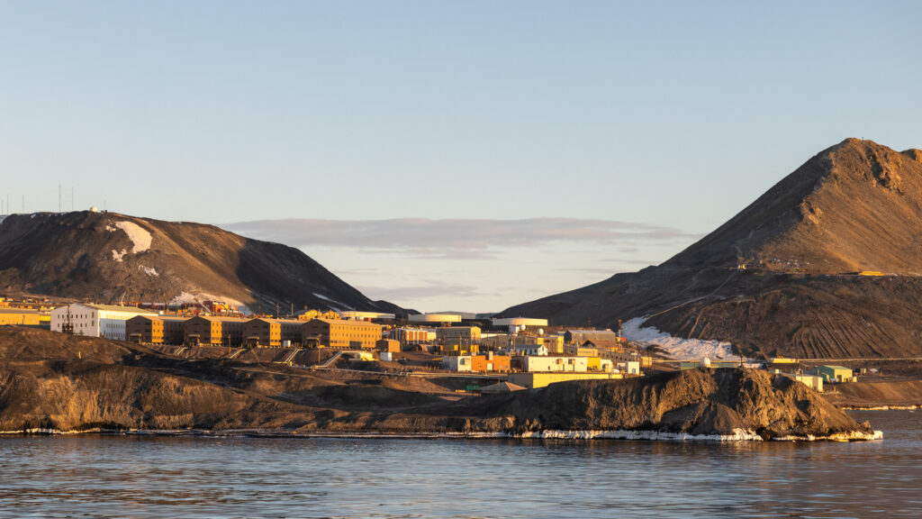 Die Forschungsstation McMurdo liegt zwischen dunklen Hügeln direkt an der Küste.