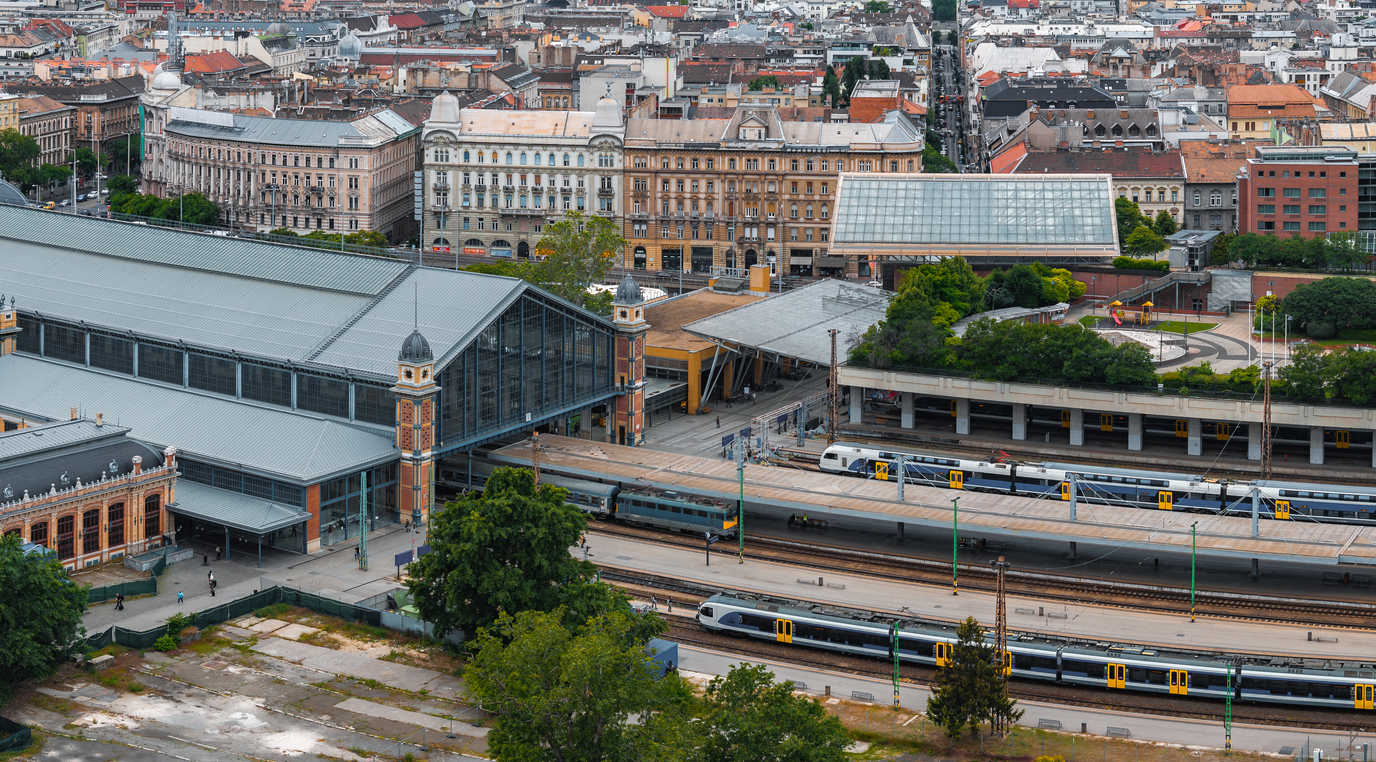 Ein großer Bahnhof mit Gleisen und Zügen liegt mitten in Budapest.
