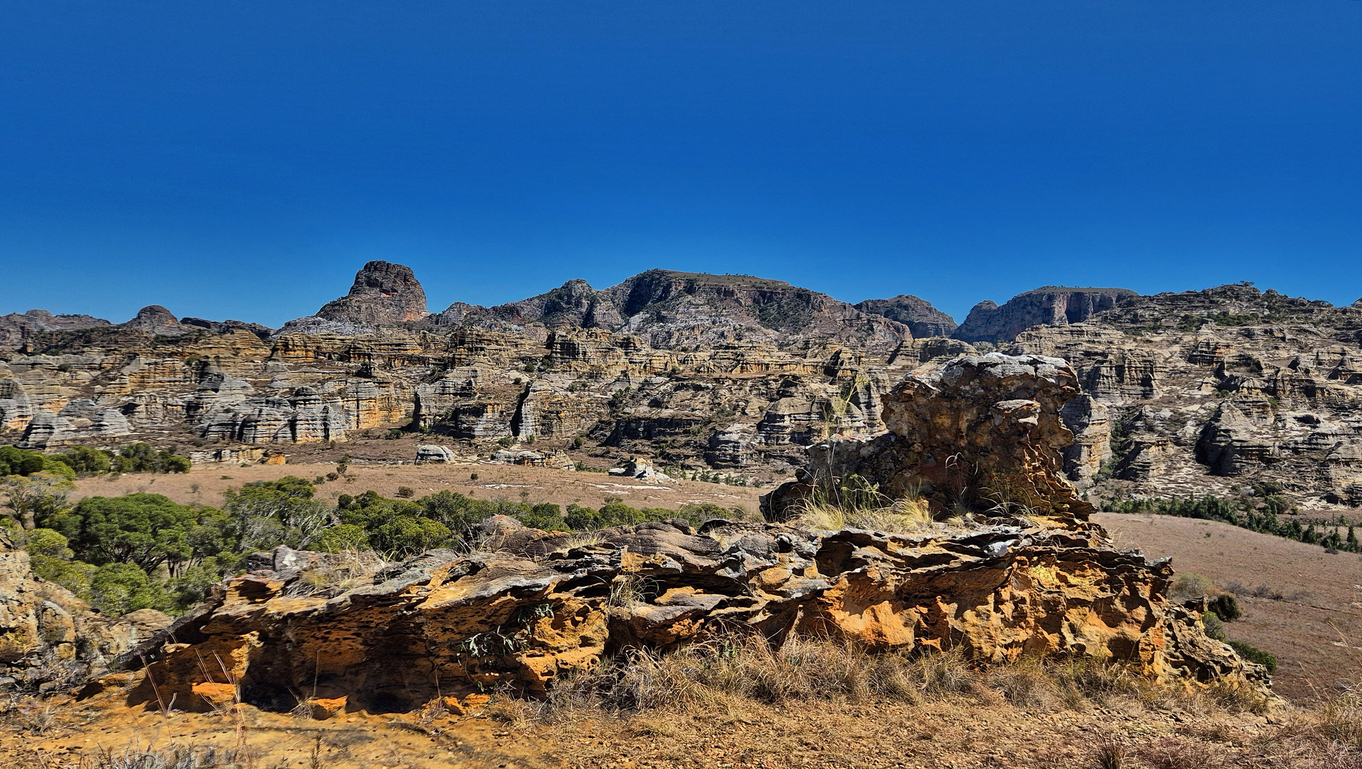 Blick auf zerklüftete Sandsteinfelsen und trockenes Grasland im Isalo Nationalpark auf Madagaskar.