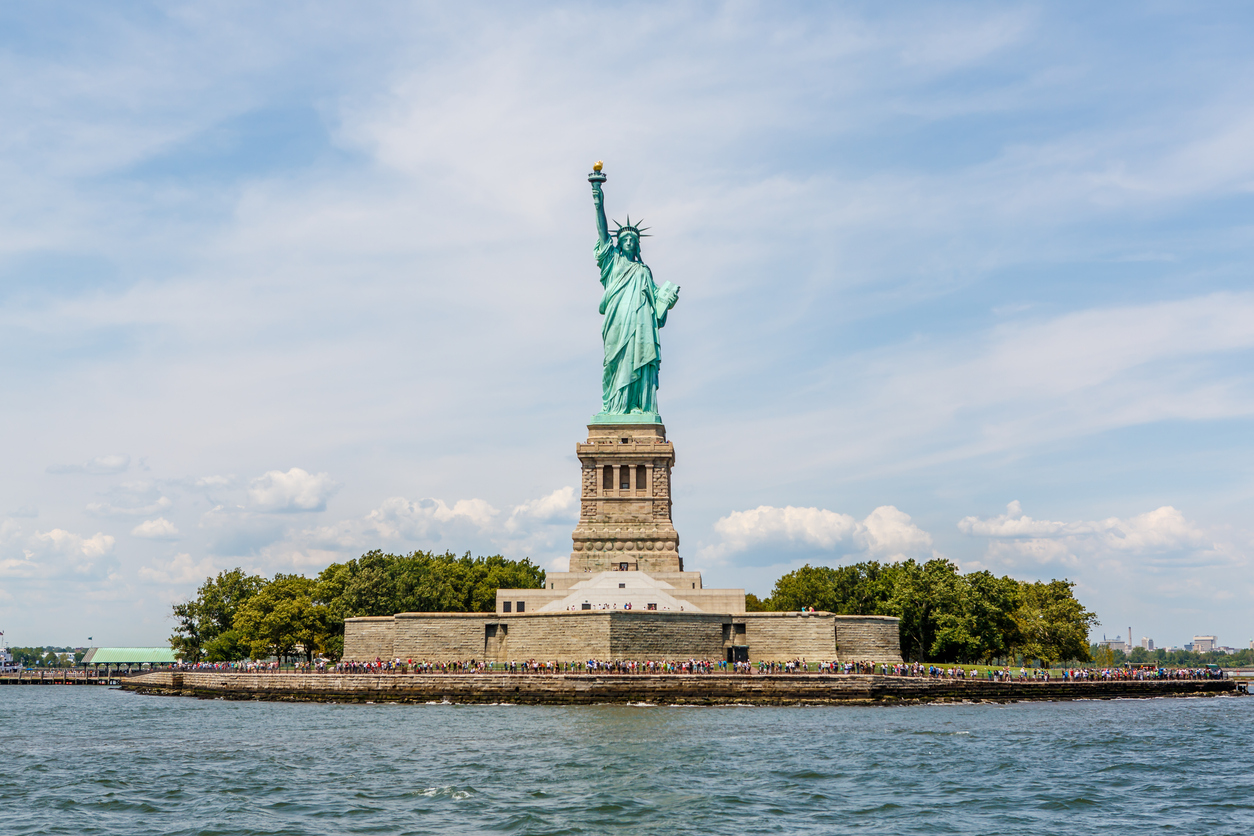 Die Freiheitsstatue steht auf Liberty Island vor dem Wasser von New York.