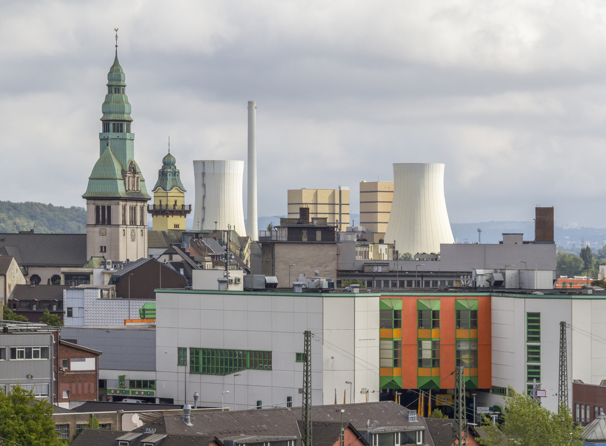 Blick über Völklingen mit Kirchturm, Stadtbebauung und markanten Industriebauten im Hintergrund.