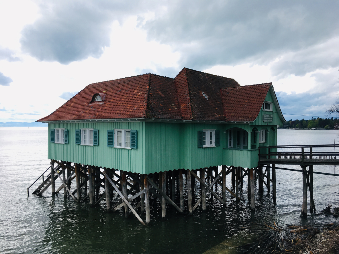 Grünes Holzhaus auf Stelzen am Bodensee bei Lindau.