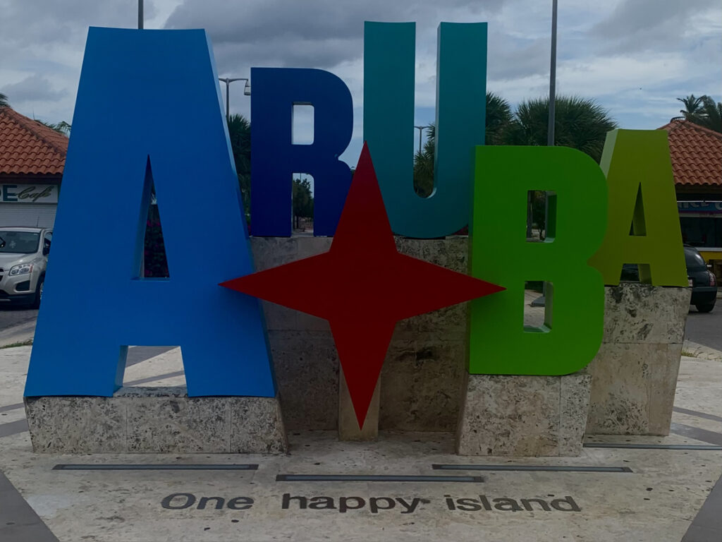 Große bunte Buchstaben formen ARUBA mit rotem Stern und dem Schriftzug One happy island.