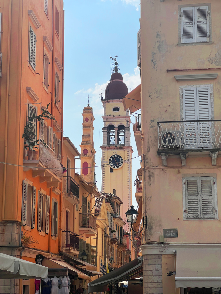 Enge Straße mit bunten Fassaden und Uhrturm in Korfu-Stadt auf Korfu.