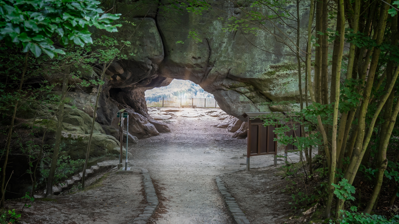 Wanderweg führt durch ein großes Felsentor aus Sandstein in der Sächsischen Schweiz.