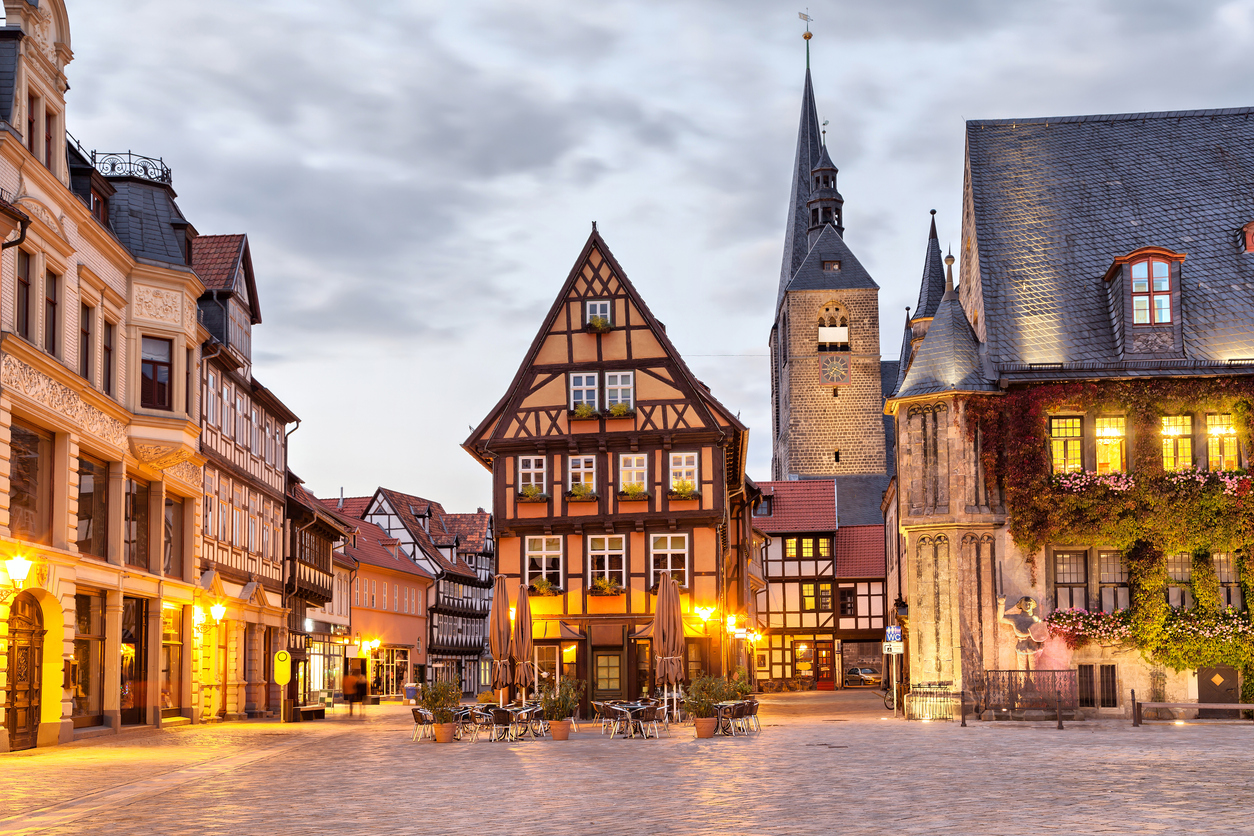 Am Abend liegt der Marktplatz in Quedlinburg mit Fachwerkhaus und Turm in warmem Licht.