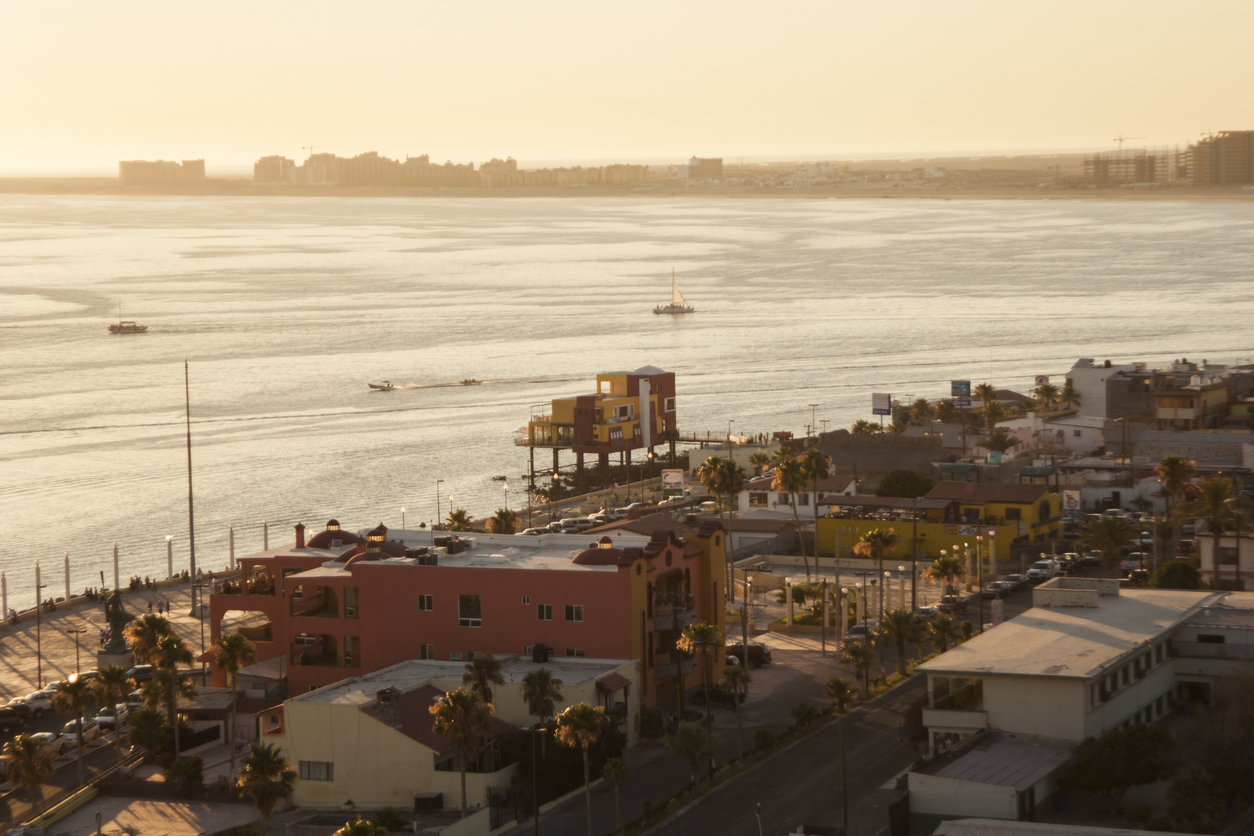 Blick auf Puerto Peñasco bei Sonnenuntergang mit Küste, Straßen und Booten im Wasser.