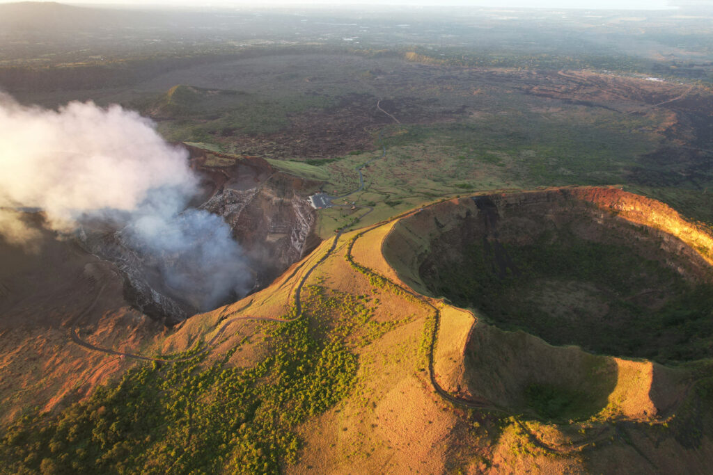 Blick in einen Vulkankrater mit Rauch und Kraterwänden in Nicaragua.