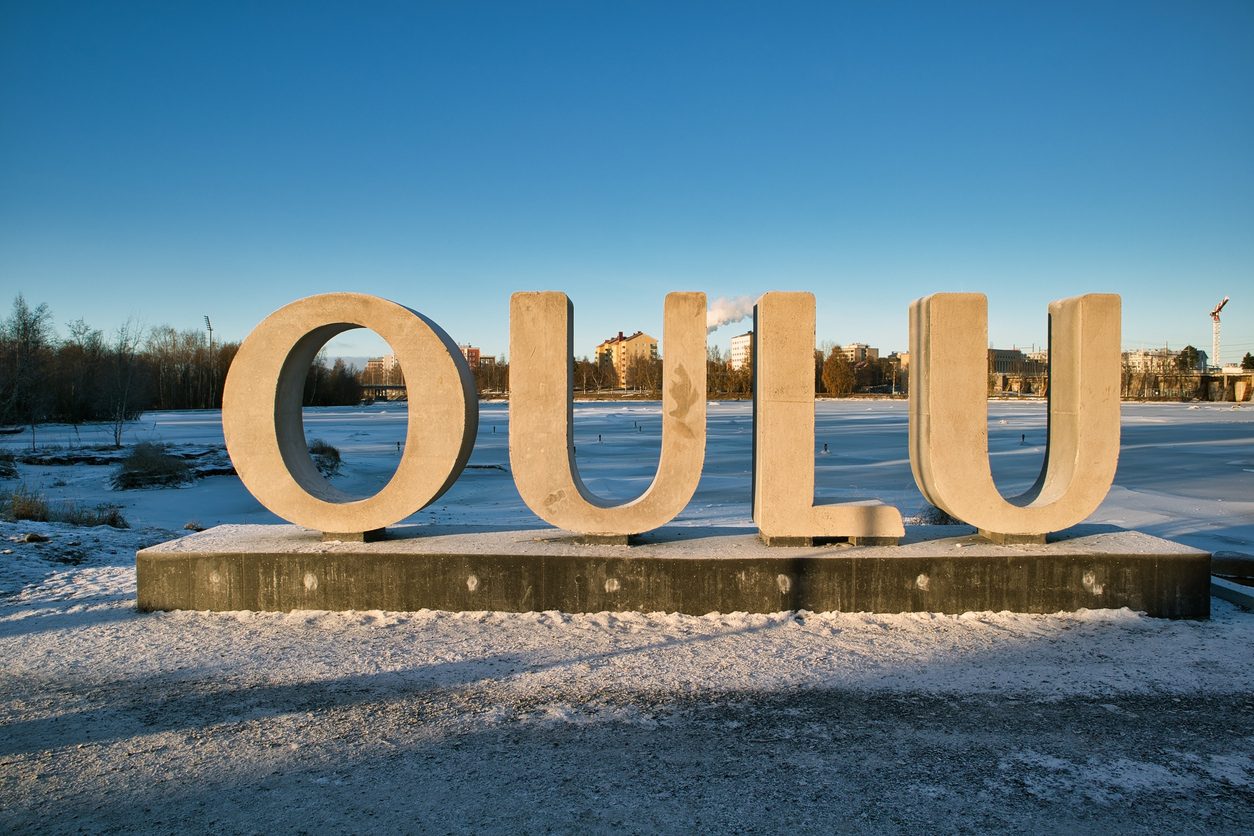 Großer Schriftzug „OULU“ vor einer verschneiten Wasserfläche in Oulu.