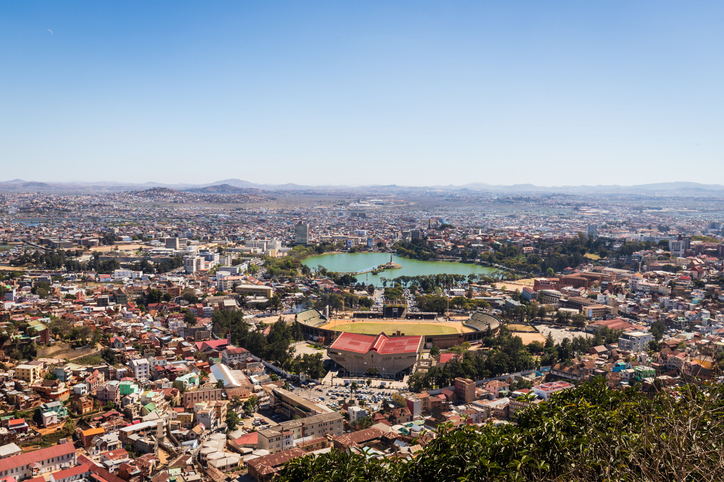 Ein weiter Blick aus der Vogelperspektive über das Stadtgebiet auf den Lac Anosy mit seinem zentralen Denkmal und das große Nationalstadion.