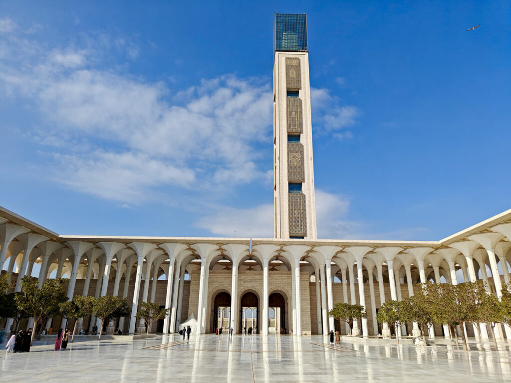 Weitläufiger Hof der Großen Moschee von Algier mit Arkaden und hohem Minarett.