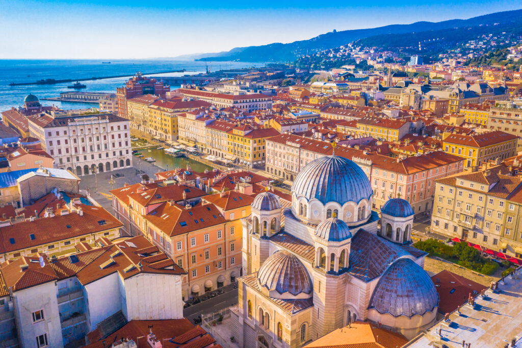 Luftaufnahme von Altstadt und Hafen mit kuppelreicher Kirche im Vordergrund.