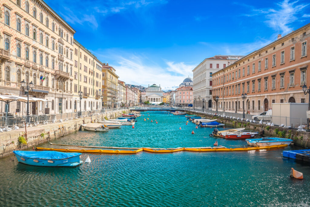 Kanal mit türkisfarbenem Wasser, Booten und Häuserfronten auf beiden Seiten.