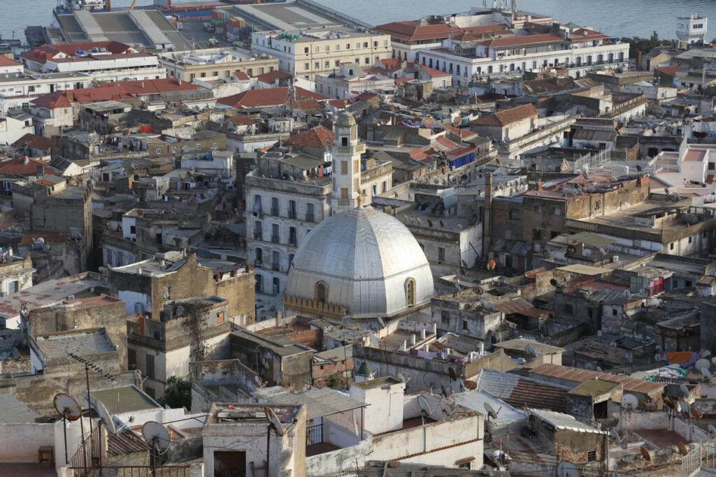 Luftaufnahme der Altstadt von Algier mit vielen Flachdächern und einer großen weißen Kuppel.