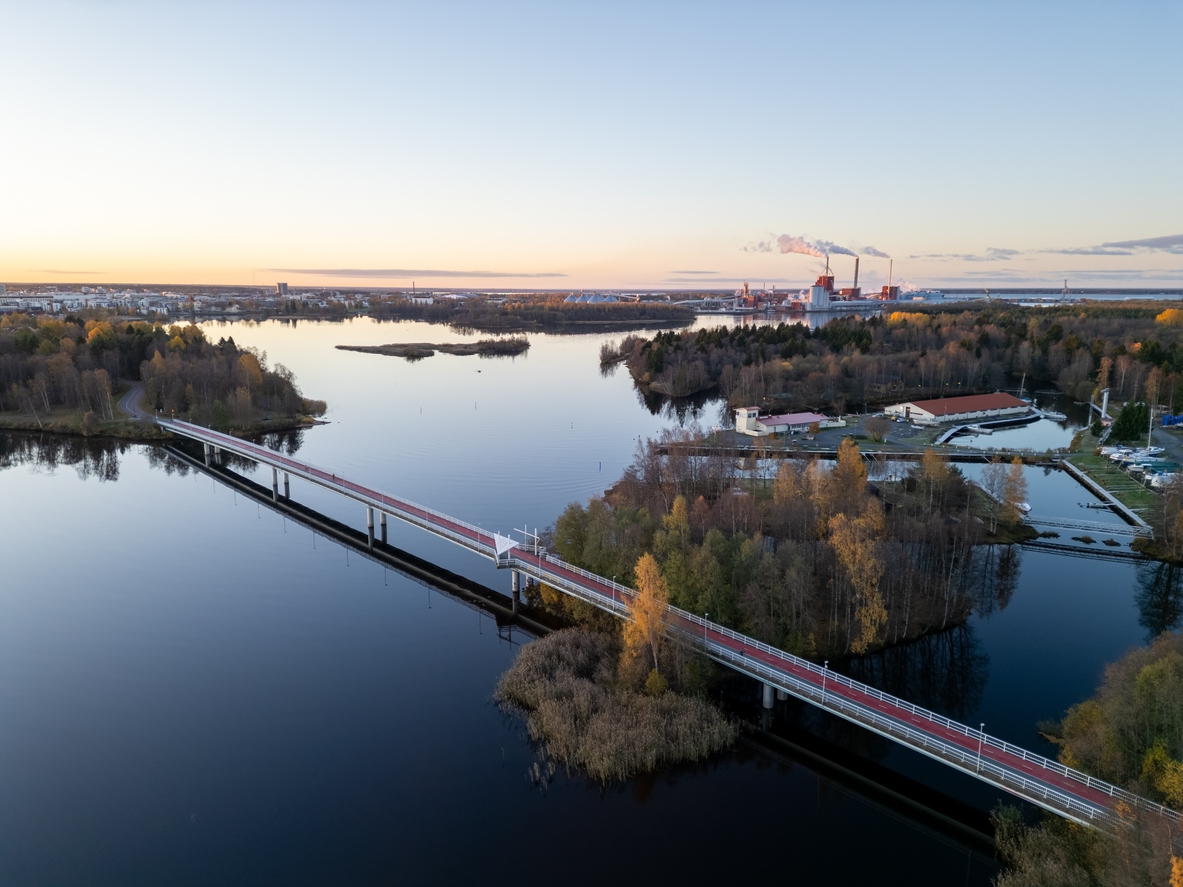 Luftaufnahme einer breiten Straße mit Brücke und Stadtvierteln in Oulu.