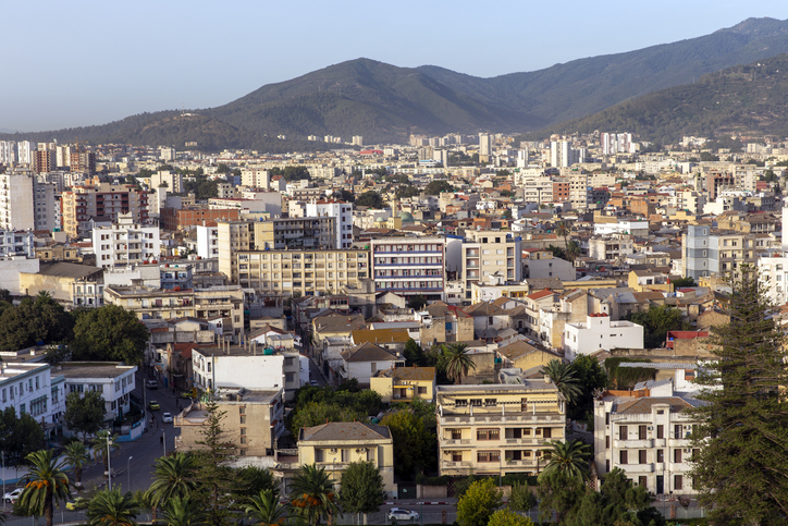 Ein Blick über die dichte Bebauung von Annaba mit modernen Apartmenthäusern vor den grünen Ausläufern des Atlas-Gebirges.
