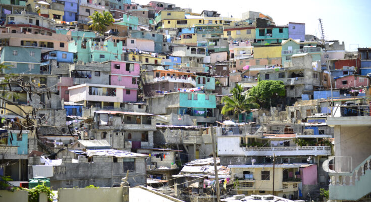 Ein dichtes Häusermeer aus grauen Betonbauten und bunt gestrichenen Fassaden erstreckt sich über einen steilen Hang.